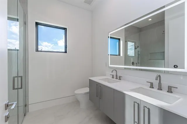 a bathroom with a toilet sink and mirror