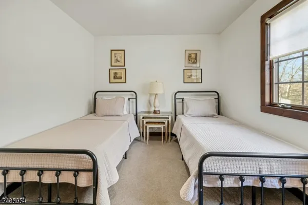 a bedroom with two beds and windows