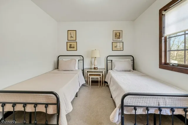 a bedroom with two beds and windows