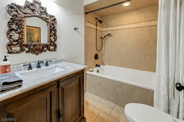 a bathroom with a granite countertop sink toilet mirror and shower