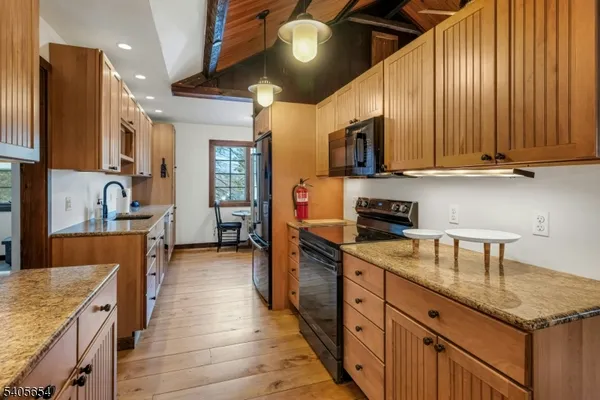 a kitchen with stainless steel appliances granite countertop wooden cabinets a stove top oven a sink and dishwasher
