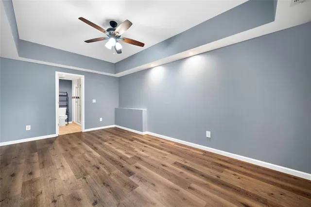 a view of an empty room and cabinet and a ceiling fan