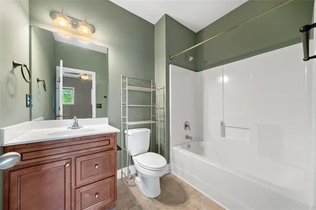 a bathroom with a granite countertop sink toilet a large mirror a bathtub and shower