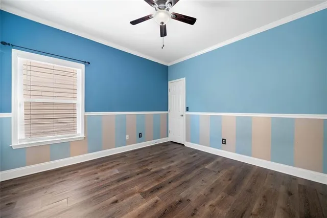 a view of an empty room with window and wooden floor