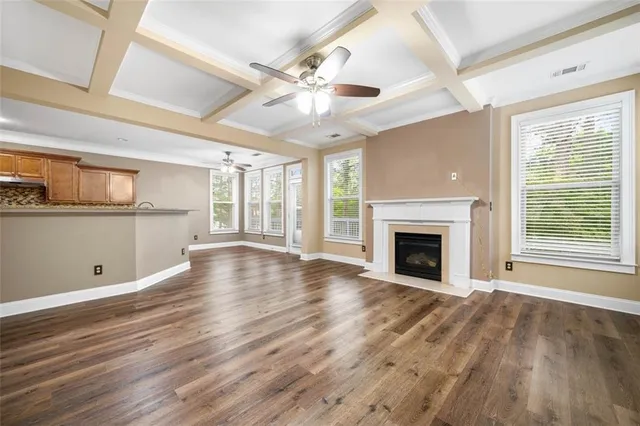 a view of empty room with wooden floor and fireplace