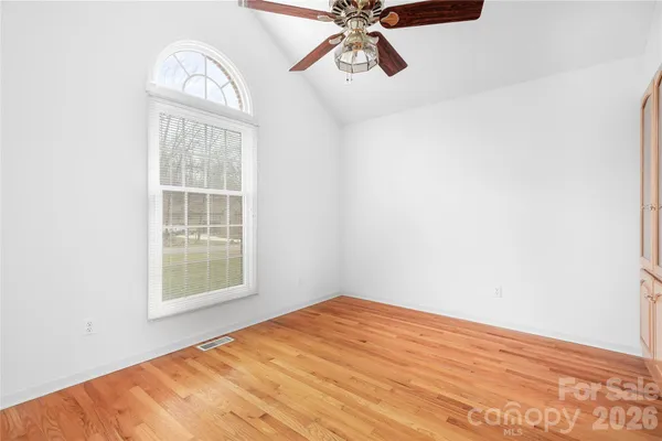 an empty room with windows and fan