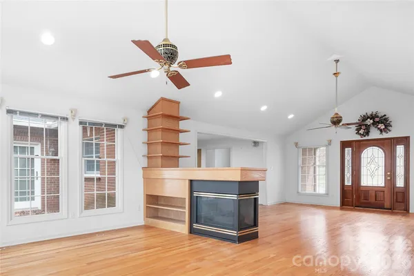 a view of an empty room with a window and fireplace