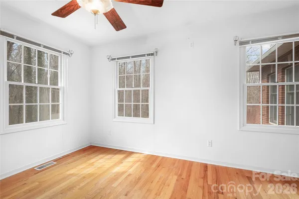 an empty room with a window and wooden floor