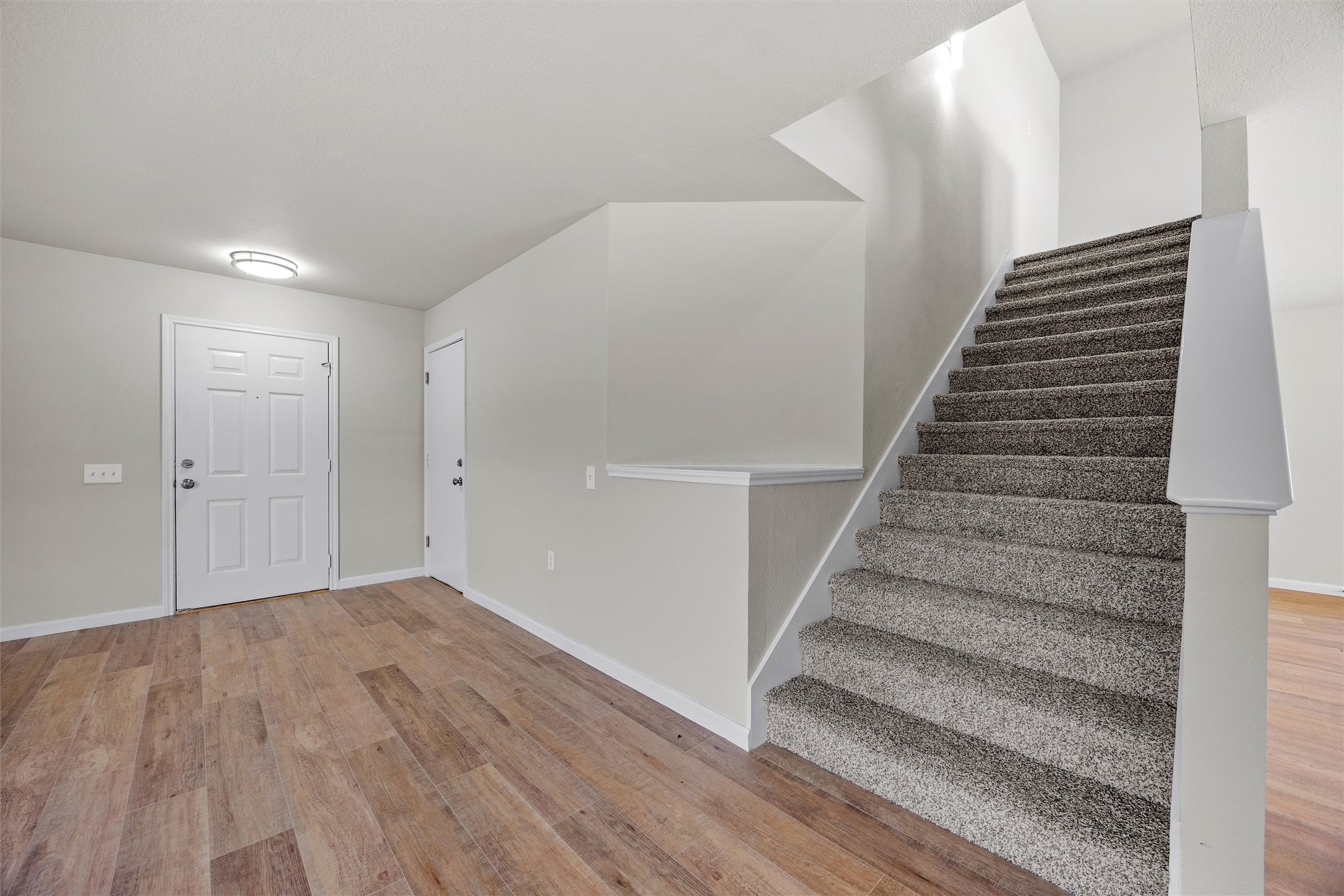 7541 Redrick Drive Austin, TX 78747 - Photo 14 of 40 Foyer entrance with stairway, baseboards, and wood finished floors