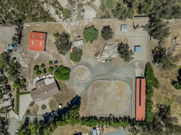 an aerial view of a house with a yard and a large tree