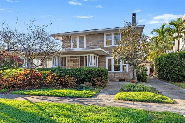 a front view of a house with a garden and plants