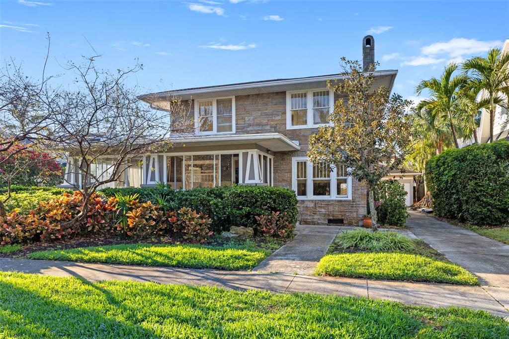 a front view of a house with a garden and plants