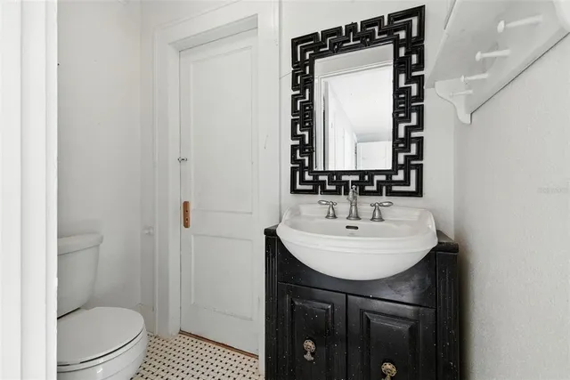 a bathroom with a sink toilet and mirror