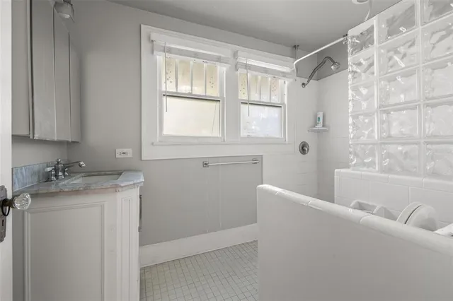 a bathroom with a granite countertop sink mirror and a bathtub
