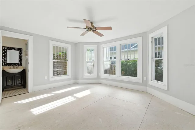a view of an empty room with a window and kitchen view