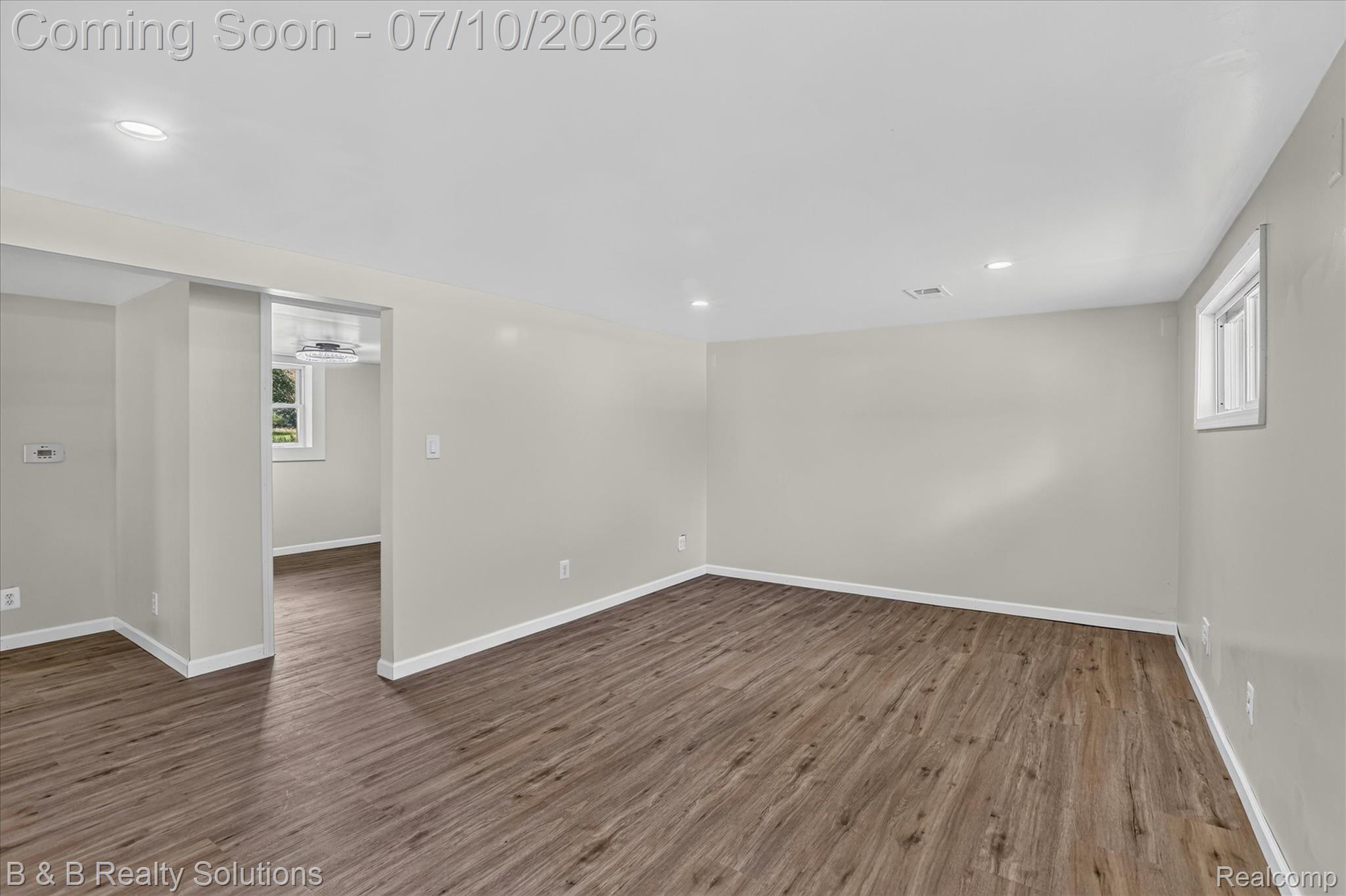 1564 East Burnside Road North Branch, MI 48461 - Photo 13 of 25 Spacious room featuring wood-finish flooring, light gray wall paint, white baseboards, and recessed ceiling lighting