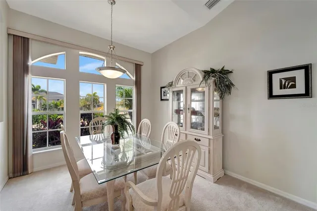 a dining room with furniture a chandelier and window
