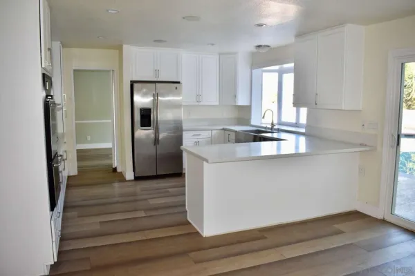 a kitchen with granite countertop a refrigerator and a sink