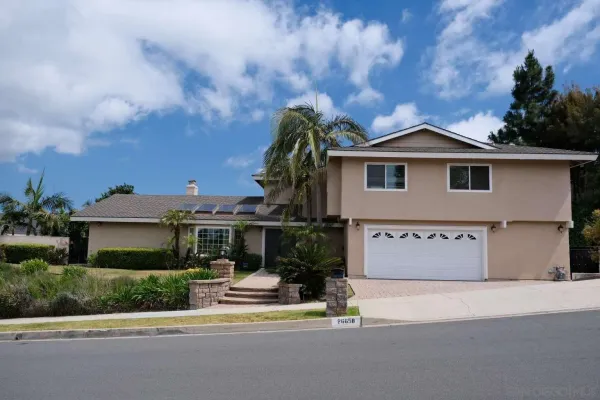 a front view of a house with a garden and yard