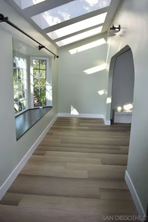 a view of entryway and hall with wooden floor