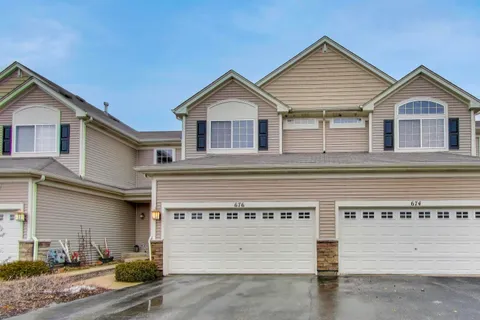 a view of a house with a garage and yard