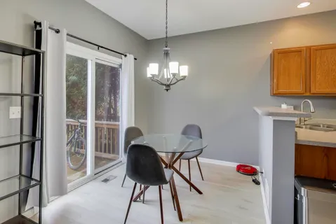 a dining room with furniture a chandelier and window
