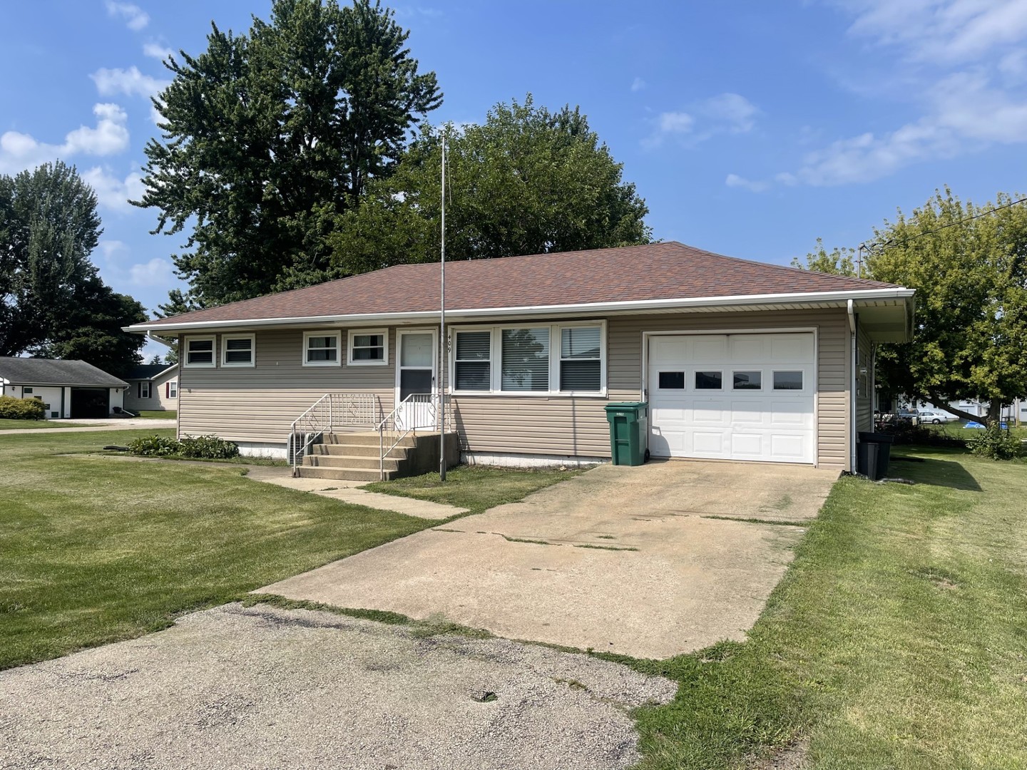 a front view of a house with a yard and trees