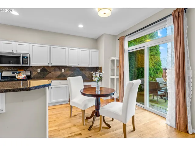 a kitchen with a table chairs refrigerator and cabinets
