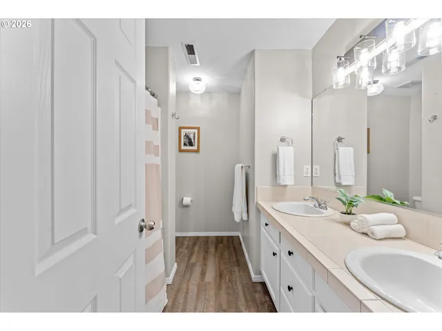 a spacious bathroom with a double vanity sink and a mirror
