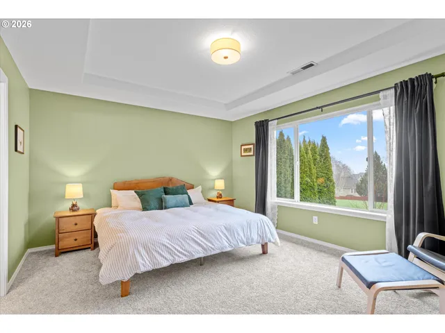 a bedroom with a bed and large windows