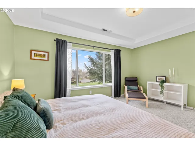 a bedroom with a bed and a large window