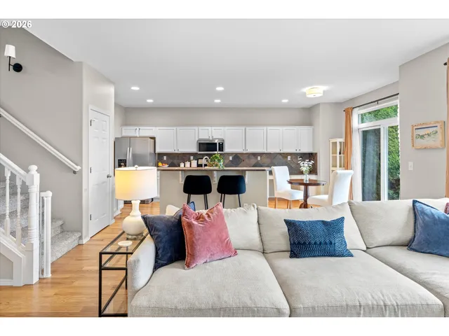 a living room with a couch and a dining table with kitchen view