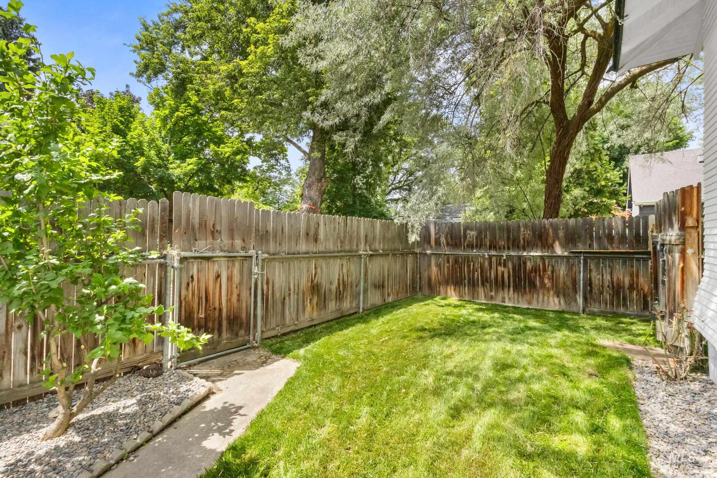 2119 West Brumback Street Boise, ID 83702 - Photo 26 of 30 Private fenced yard featuring a manicured lawn and mature perimeter trees
