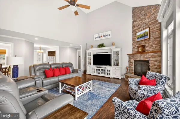 a living room with furniture a flat screen tv and wooden floor