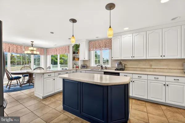 a large kitchen with stainless steel appliances a large counter top a stove and a sink