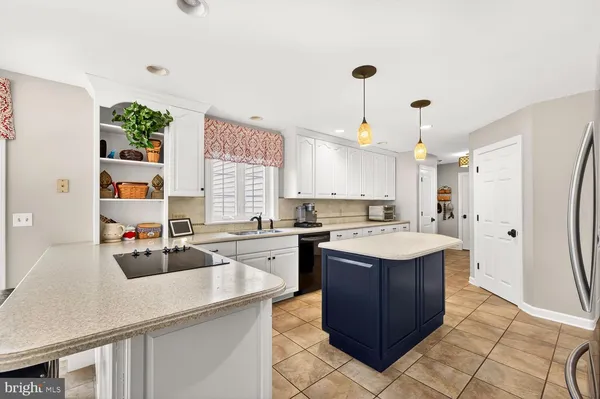 a kitchen with stainless steel appliances granite countertop a sink and dishwasher a refrigerator with white cabinets