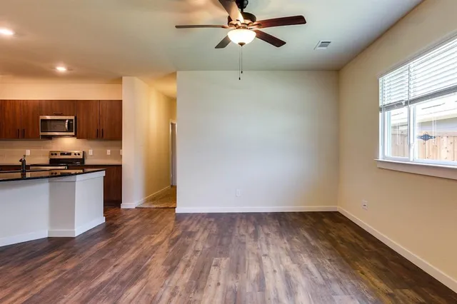 a view of a kitchen with a sink and dishwasher with wooden floor
