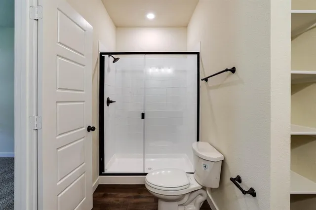 a bathroom with a granite countertop shower and a toilet