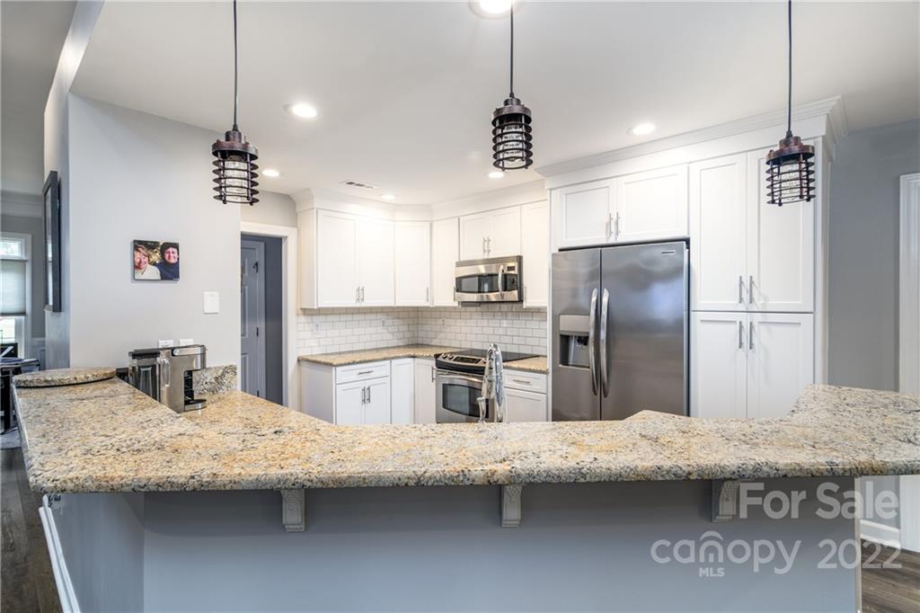3364 Blue Jay Pass Fort Mill, SC 29708 - Photo 6 of 30 a kitchen with granite countertop kitchen island stainless steel appliances a refrigerator a sink a stove a dining table and chairs