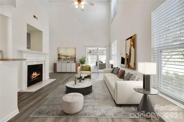 a living room with furniture a fireplace and a large window