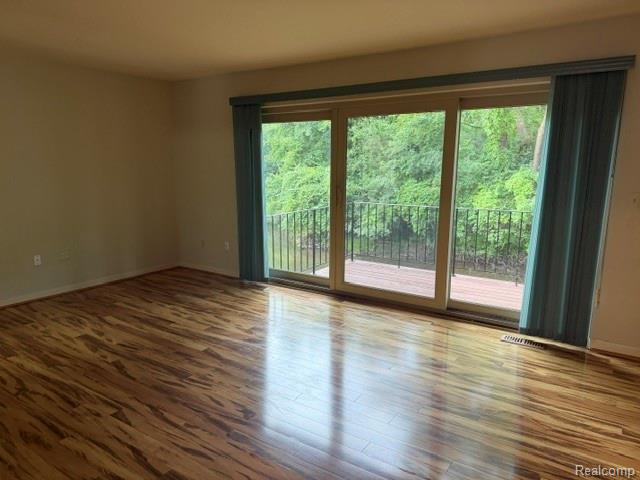 629 Oakbrook West, Unit 18 Rochester, MI 48307 - Photo 15 of 18 Wood-finish flooring throughout, sliding glass door leading to a private outdoor deck, and natural light