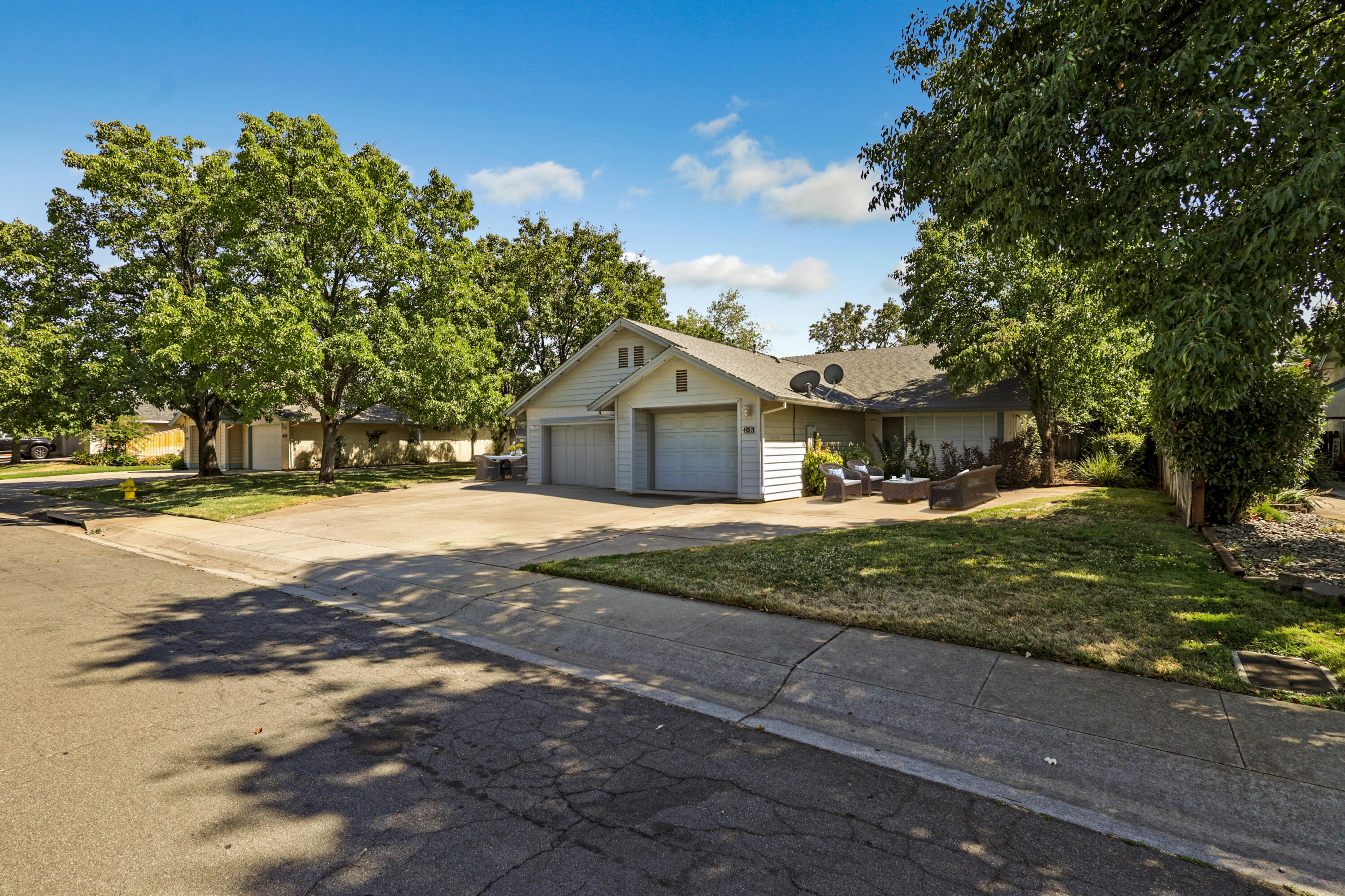 4439 Lynbrook Loop Redding, CA 96003 - Photo 2 of 3 a front view of a house with a yard and large trees