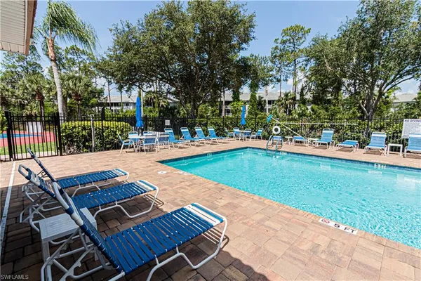 a view of a swimming pool with lounge chairs in patio