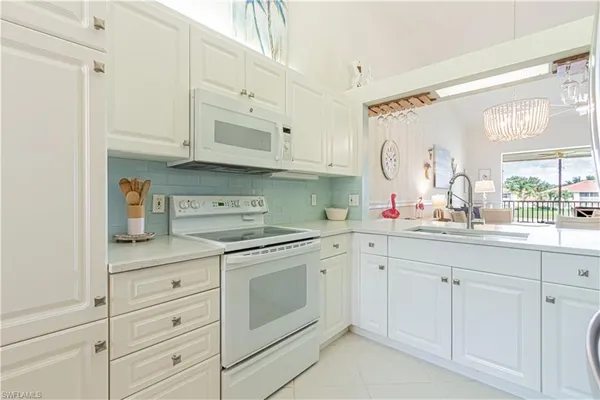 a kitchen with white cabinets and white appliances