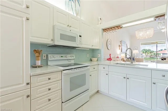 a kitchen with white cabinets and white appliances