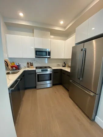 a kitchen with stainless steel appliances granite countertop a refrigerator a sink a stove a microwave and island