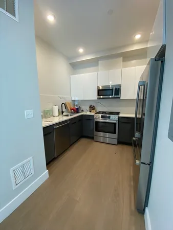 a kitchen with stainless steel appliances a sink a stove a refrigerator a microwave a sink and a refrigerator