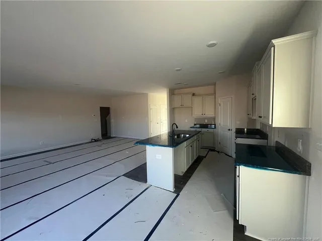 a kitchen with granite countertop a sink and cabinets