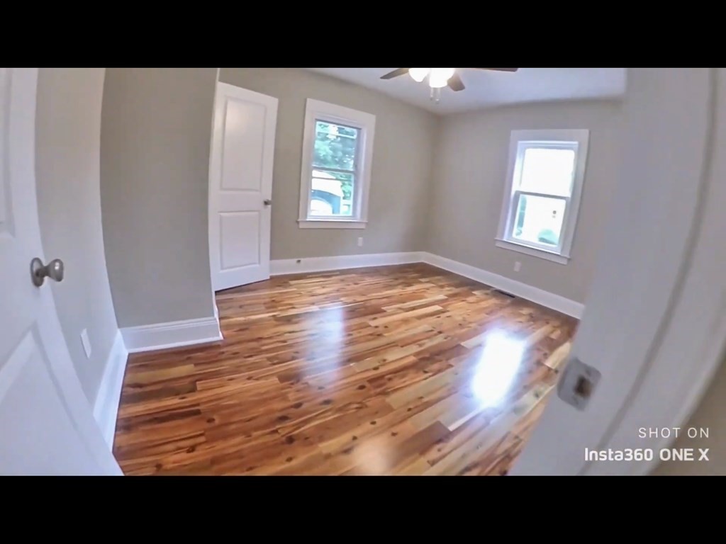 103 Lexington Street, Unit 103 Newton, MA 02466 - Photo 11 of 19 a view of an empty room with wooden floor and a window