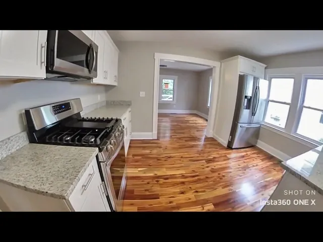 a kitchen with stainless steel appliances kitchen island sink refrigerator stove and microwave